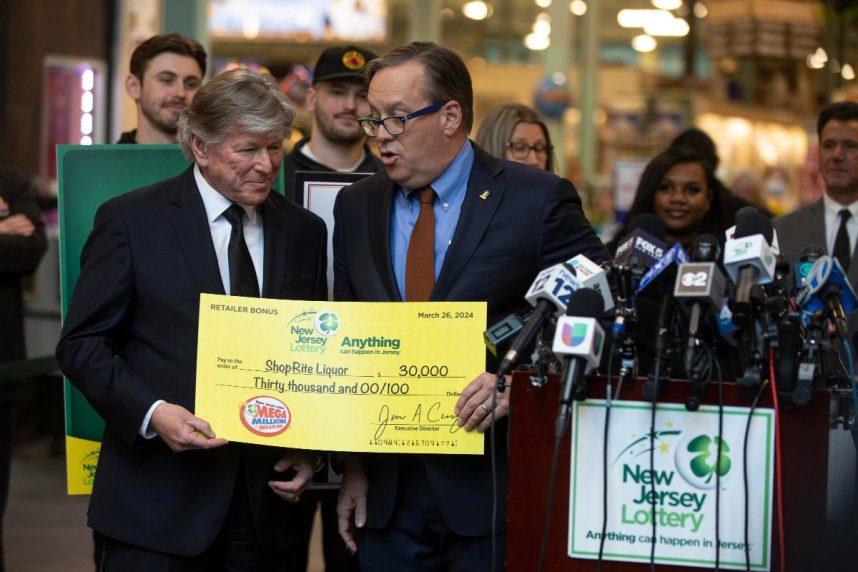 Two men present oversized check